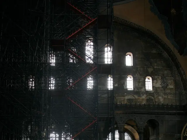 In this picture I can see a building with windows, there are iron grilles and stairs.