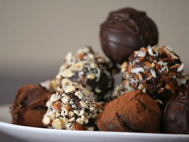 In this picture, we see a white plate containing the chocolates. In the background, we see a wall...