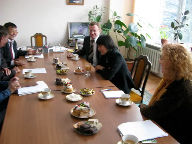 It looks like an office ,some people are sitting around the table ,on the table there are some...