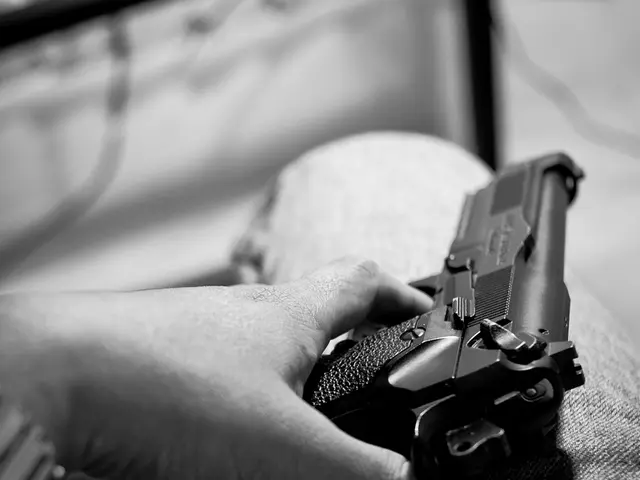 This is the black and white image where we can see a person's hand holding gun and kept on the leg....