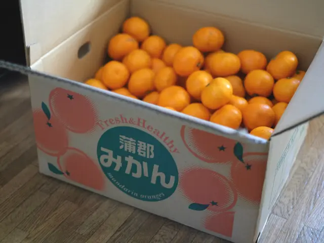 In the image there is a cardboard box. Inside the box there are oranges. And on the box there are...