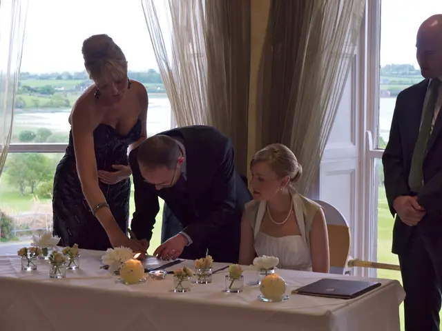 It is a meeting there is a white color table on which there are some flowers ,a candle and book are...