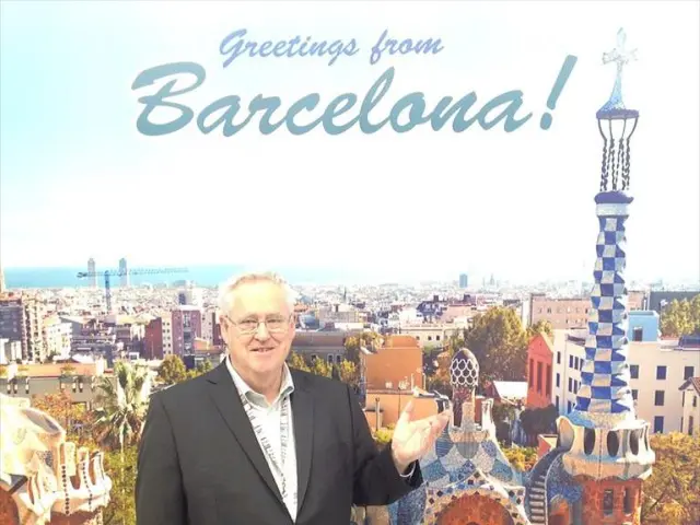 In the image there is a man and behind the man there is poster containing many buildings and towers...