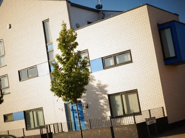 This image consists of a building which is in white color. It has a compound wall in the bottom. It...