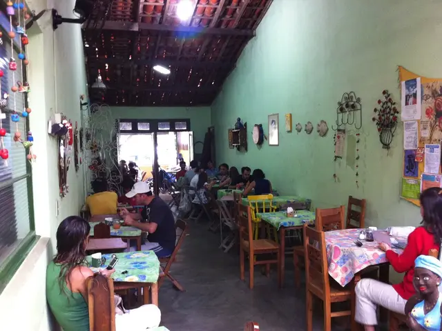 In this image there are group of people sitting on the chair. On the table there is a tissue...