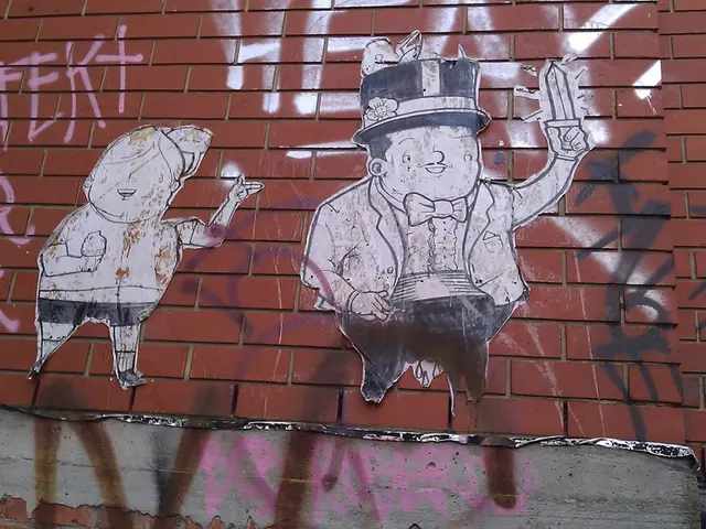 The picture consists of a brick wall, on the wall there are posters and graffiti.