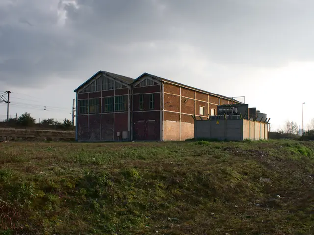 In this image we can see sheds, transformers, electric poles, electric cables, fences, street pole,...