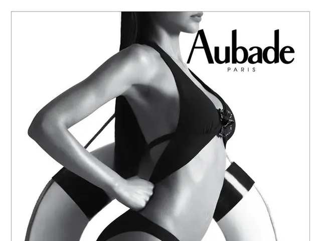 There is a woman standing and holding a tube and we can see text,in the bottom left side of the...