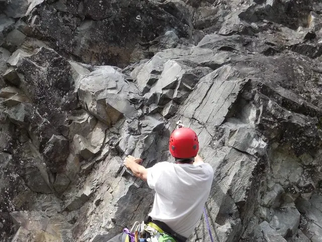 In the center of the image there is a person wearing a red color helmet and white color t-shirt. he...