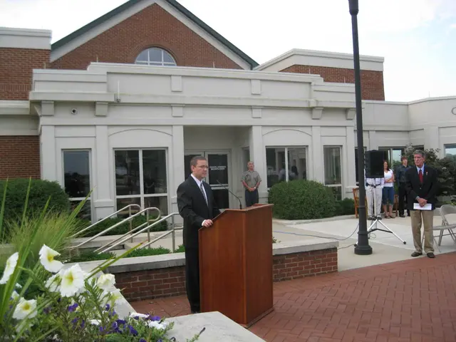 In this image there is a house with the glass windows in the background. In front of it there is a...