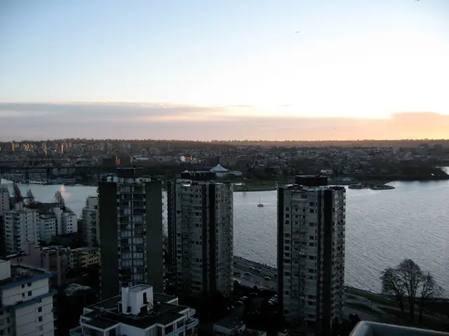 There are many buildings with windows. There is a road with vehicles. On the right side there is a...