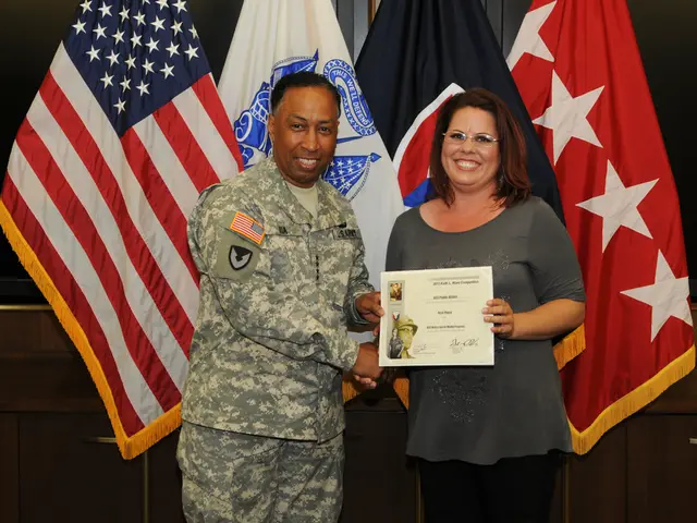 In the image there is a man in camouflage dress standing on the left side holding a paper and...