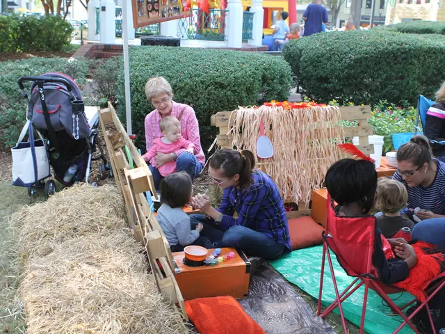 In the foreground of this image, there are women and children. We can also see cushions, wooden...
