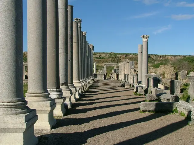 The picture is taken near a monument. In the foreground of the picture there are pillars and walls....