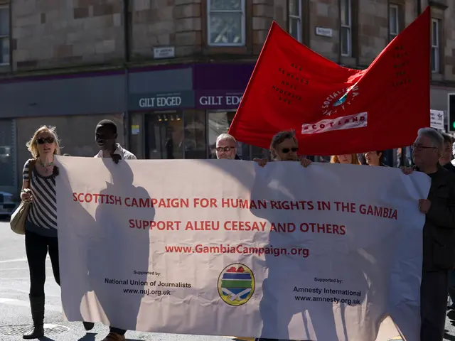 As we can see in the image there is a building, banners, traffic signal and few people here and...