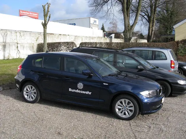 In this image I see few cars over here and I see the path and I see the green grass. In the...