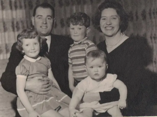 In this image we can see a family of five persons. Here we can see a man on the left side is...