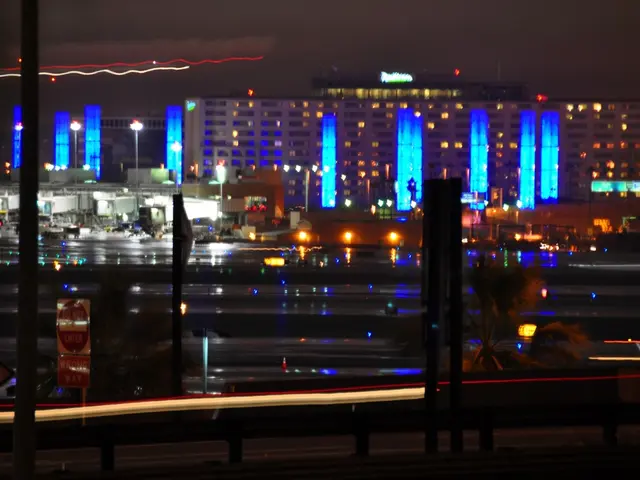 In this picture I can see there are some buildings here and they are some plants, trees and roads...