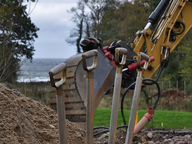 In this image there is an object placed on the sand, behind that there is a JCP. In the background...