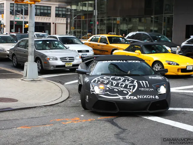 In this image in the center there are a group of cars, and also there are some poles. At the bottom...
