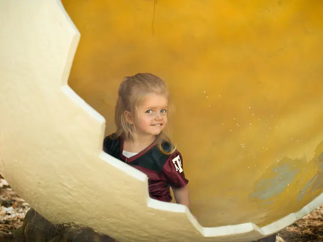 In the center of the image there is a girl. In the background we can see globe and ground.