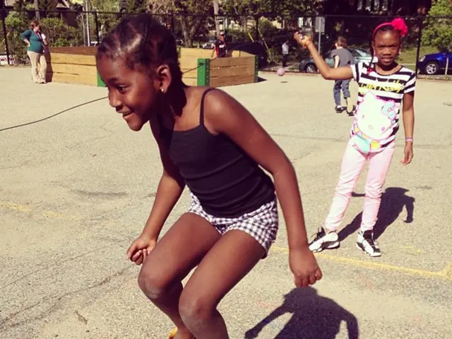 As we can see in the image there are few people here and there, fence, trees and in the background...