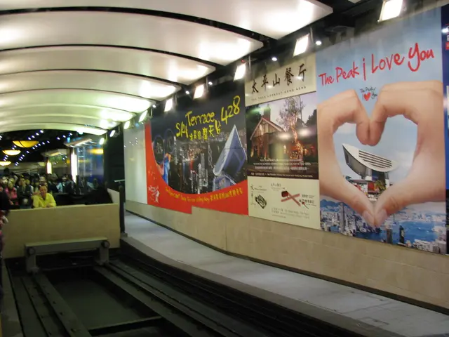 On the left side of the picture, we see people sitting on the chairs. The man in yellow T-shirt is...