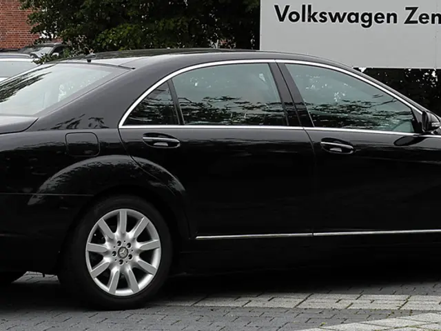 In this image we can see some cars parked near the wall, one pipe attached to the wall, some trees,...