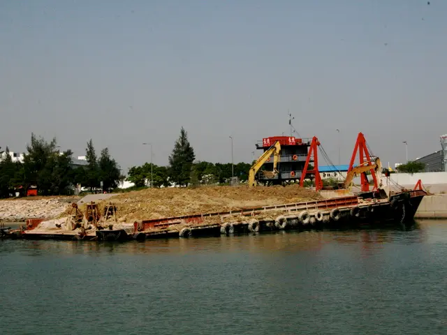 In this image there is a boat in the water, there are few cranes, few trees, buildings,...