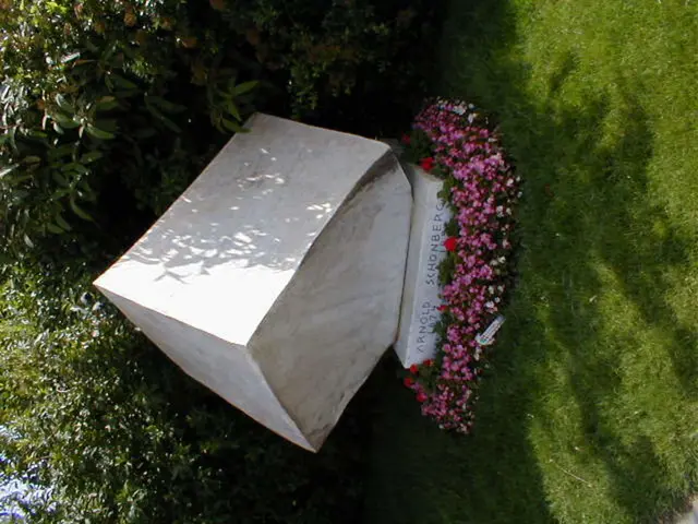 In this image I can see the memorial. In-front of the memorial I can see the flowers which are in...