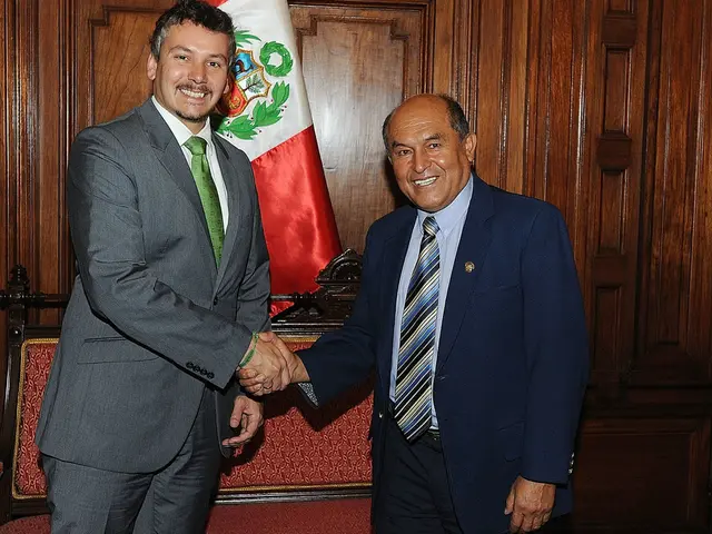 In this image in the center there are two persons standing, and they are shaking hands with each...