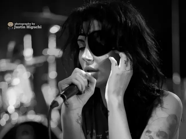 This is a black and white picture. In this picture we can see a woman holding a microphone and...