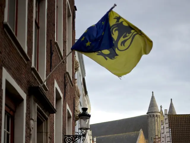 This is the picture of a city. In this image there are buildings and there are group of people on...