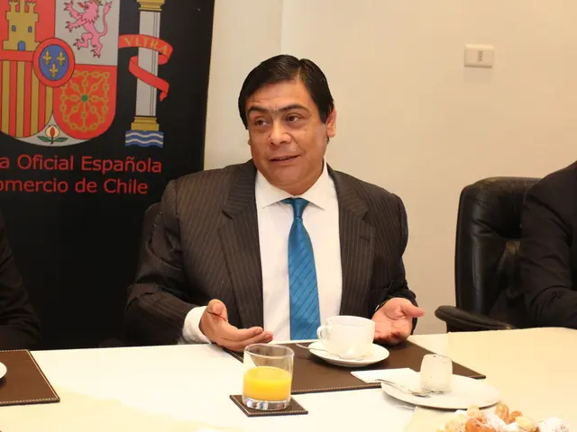 In this image I can see there are people sitting on the chair. In-front of them there is a...