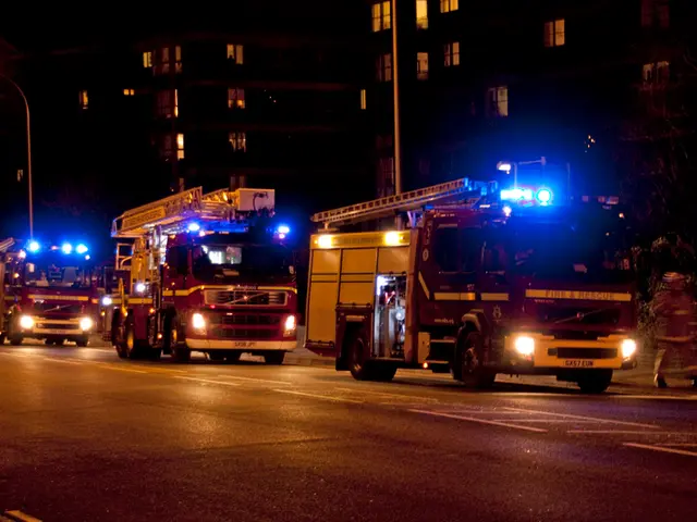 In the center of the image there are fire extinguisher trucks on the road. In the background of the...