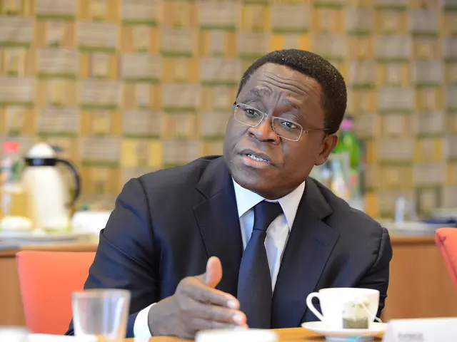 This is the man sitting on the chair and talking. This is the table with cup and saucer,glass and...