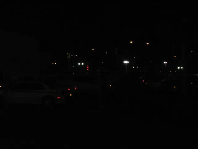 In this picture there is a car on the left side of the image and there are lamp poles in the image.