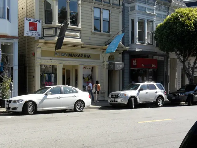 In the middle of the image there are some vehicles on the road. Behind the vehicles few people are...