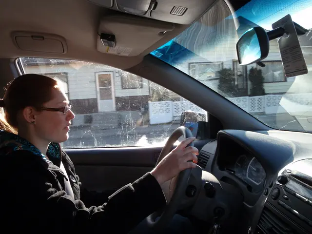 The image is taken in the car. In the car there is a lady who is driving the car.