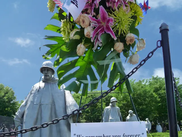 In this image we can see there are many statues of a soldier and at the top there are some flowers...