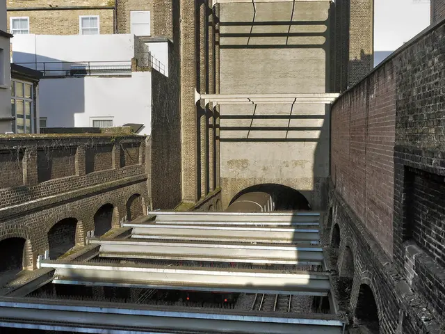 In this picture I can see there are some buildings and there is a tunnel and train is passing from...