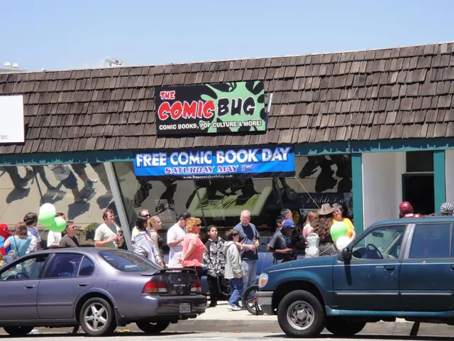 There are groups of people standing. I can see two cars on the road. This looks like a building...