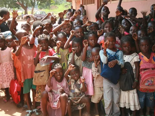 In this image I can see a group of children are standing and raising their hands. On the right side...