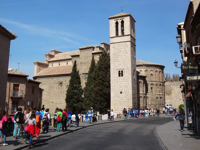 This image is clicked on the road. On the either sides of the road there is a walkway. There are...