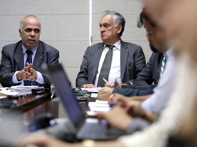 The man on the left corner of the picture wearing blue shirt and blue blazer is talking something....