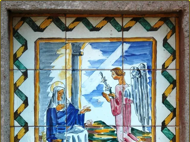 In this image there is a photo frame on the wall. In the photo frame there are depictions of people...