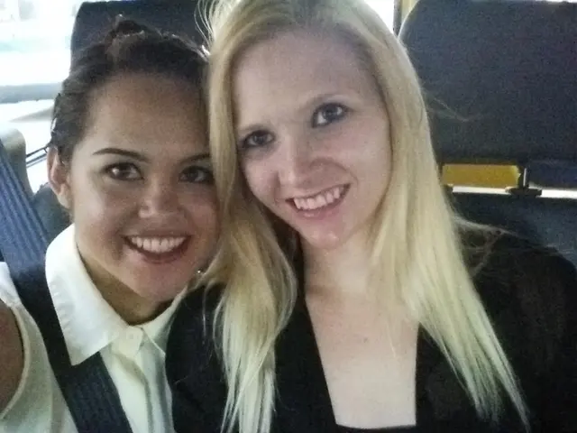 In this image we can see two lady persons wearing black and white color dress respectively sitting...