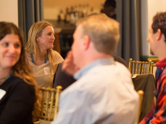 In this image we can see few persons sitting on the chairs. In the background we can see the...