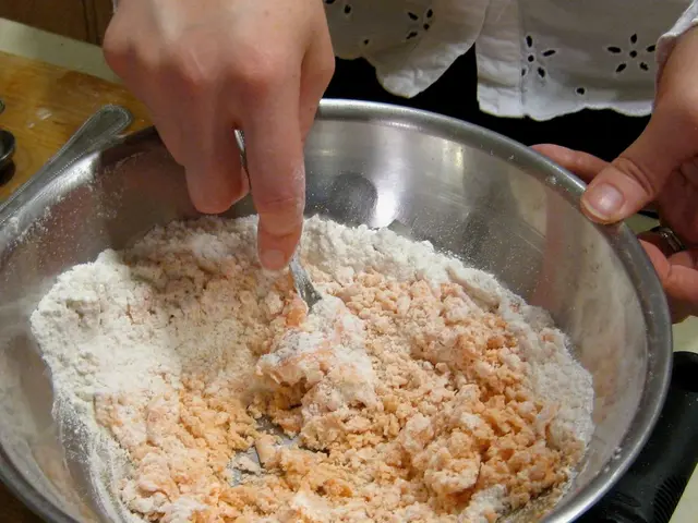 In this image, we can see the hands of a person holding steel object and bowl. In this bowl, we can...