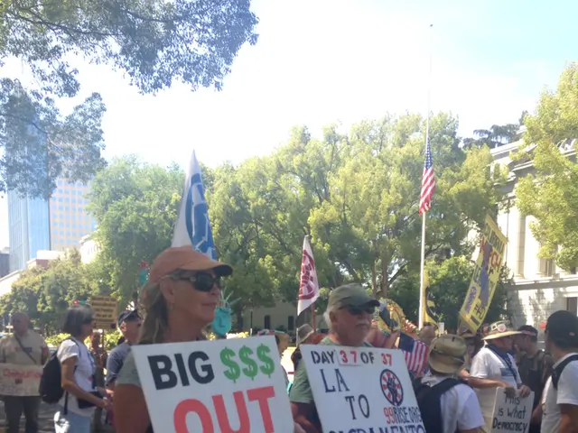 In this picture I can see trees, buildings and few people are standing holding placards with some...